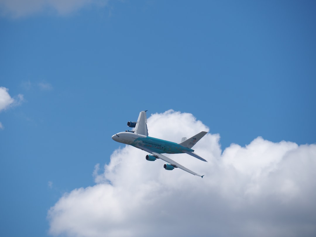 A large passenger jet flying through a cloudy blue sky